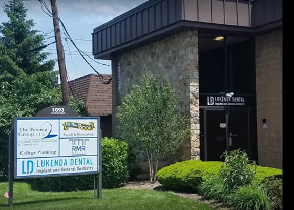 1093 Raritan Road from the street, with the Lukenda Dental sign on the building and the road sign at the kerb