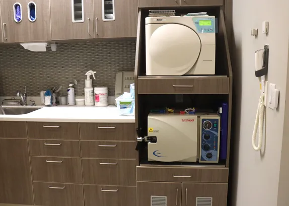 Sterilisation area with two autoclaves in a cabinet above the instrument preparation counter